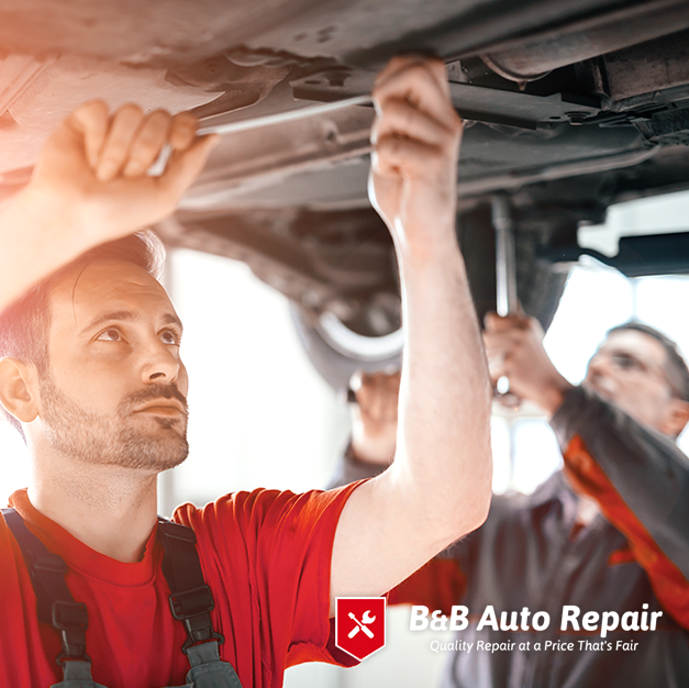 Mechanics inspecting car underside